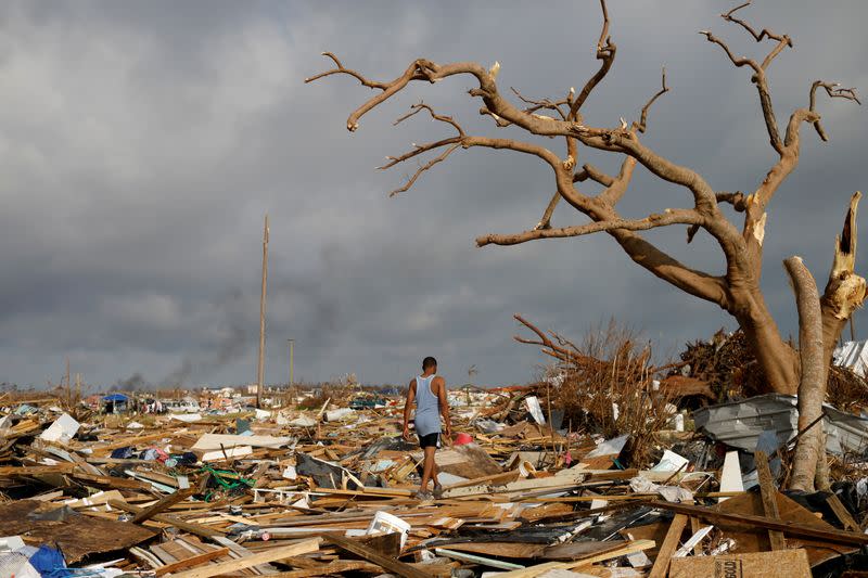 FILE PHOTO: A man walks among debris at the Mudd neighborhood, devastated after Hurricane Dorian hit the Abaco Islands in Marsh Harbour