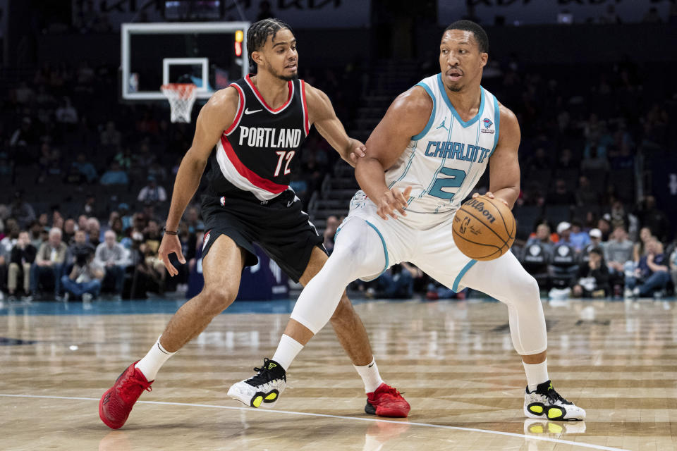 Charlotte Hornets forward Grant Williams (2) brings the ball upcourt while guarded by Portland Trail Blazers guard Rayan Rupert (72) during the first half of an NBA basketball game Wednesday, April 3, 2024, in Charlotte, N.C. (AP Photo/Jacob Kupferman)