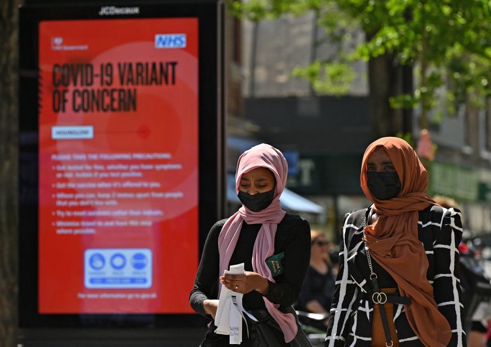 <p>Pedestrians walk past a sign warning members of the public about a "Coronavirus variant of concern' is pictured in Hounslow, west London on June 1, 2021. - A rise in cases of the Delta Covid-19 variant, first identified in India, could "pose serious disruption" to Britain's reopening plans, Prime Minister Boris Johnson warned last week. (Photo by JUSTIN TALLIS / AFP) (Photo by JUSTIN TALLIS/AFP via Getty Images)</p>
