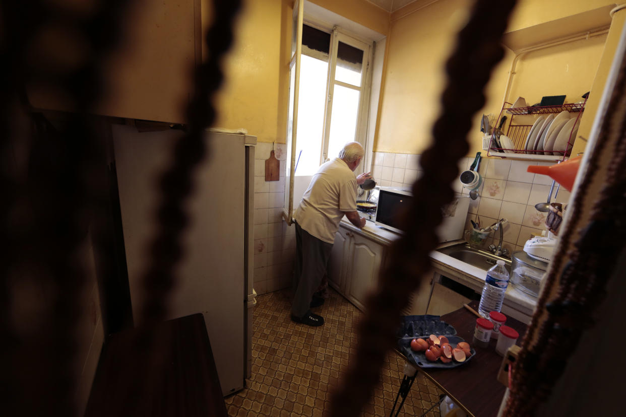 Eugene, an 87-year-old retired Frenchman, cooks foods collected from a garbage container next to a supermarket in Nice June 11, 2013. A former interior decorator, and a pensioner of  24 years, Eugene lives in Nice and is the owner of a small apartment in a bourgeois district of the city. Although he receives a monthly pension of 1000 euros (1300 $US), he started rummaging through trash bins to collect food in 2012, as he did when a teenager during World War II, because 'times are hard' he said. He drives his old car seeking out supermarket trash containers in different parts of the city to fill his fridge. Eugene dreams of going to Las Vegas. Following a government report today June 14, 2013 the French should pay contributions for longer to get a full pension and well-off pensioners should get fewer tax rebates. Picture taken June 11, 2013.  REUTERS/Eric Gaillard (FRANCE - Tags: SOCIETY POVERTY FOOD)