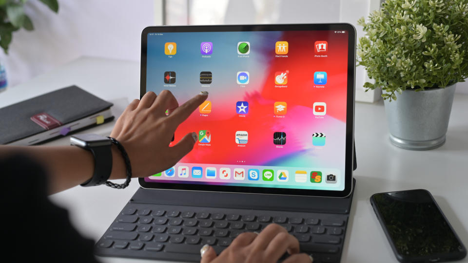 Woman using touchscreen of an iPad while also using a keyboard