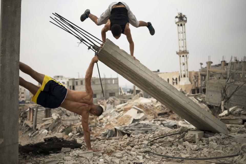 Palestinian group, Bar Palestine, take part in street exercises amid the destruction in Gaza City on August 3, 2015. Street workout, that is still new to Gaza, is a growing sport across the world with annual competitions and events. 