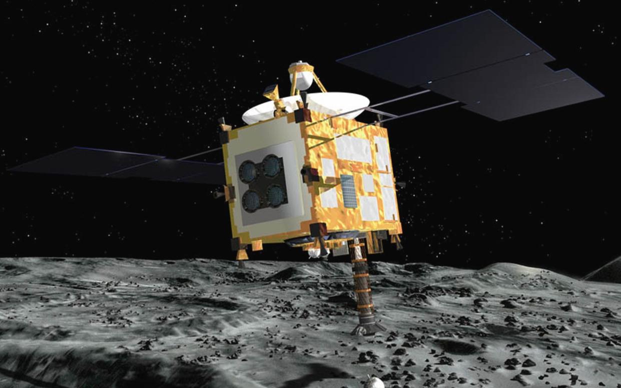 In this artist rendering released by the Japan Aerospace Exploration Agency (JAXA), the Hayabusa probe collects surface samples after landing on an asteroid.  - AP Photo/Japan Aerospace Exploration Agency, HO