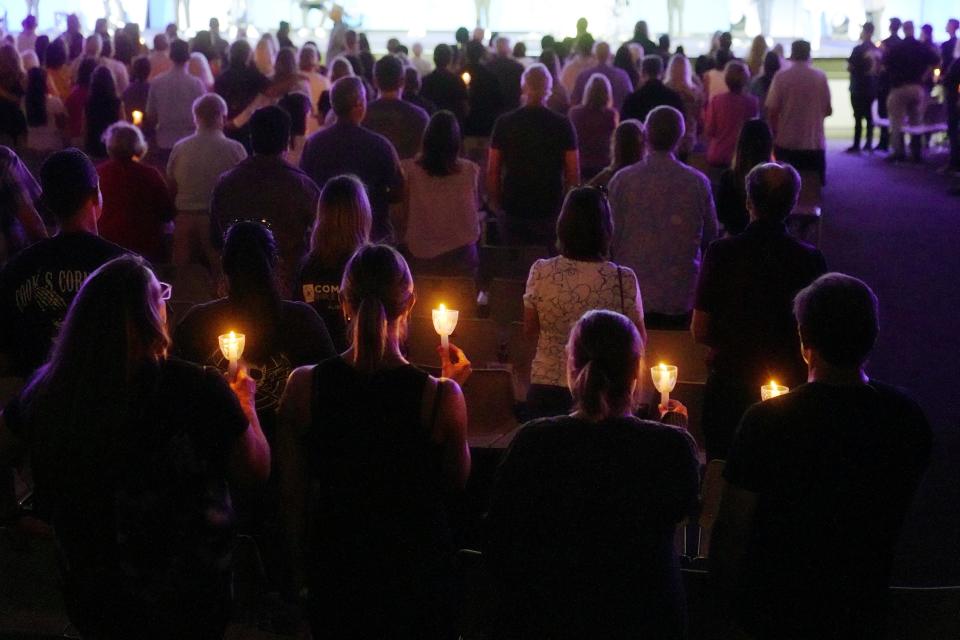 People hold lighted candles as they join in a prayer vigil Friday, Aug. 25, 2023, at Saddleback Church in Lake Forest for the victims of Wednesday's shootings at Cook's Corner in Orange County's Trabuco Canyon.