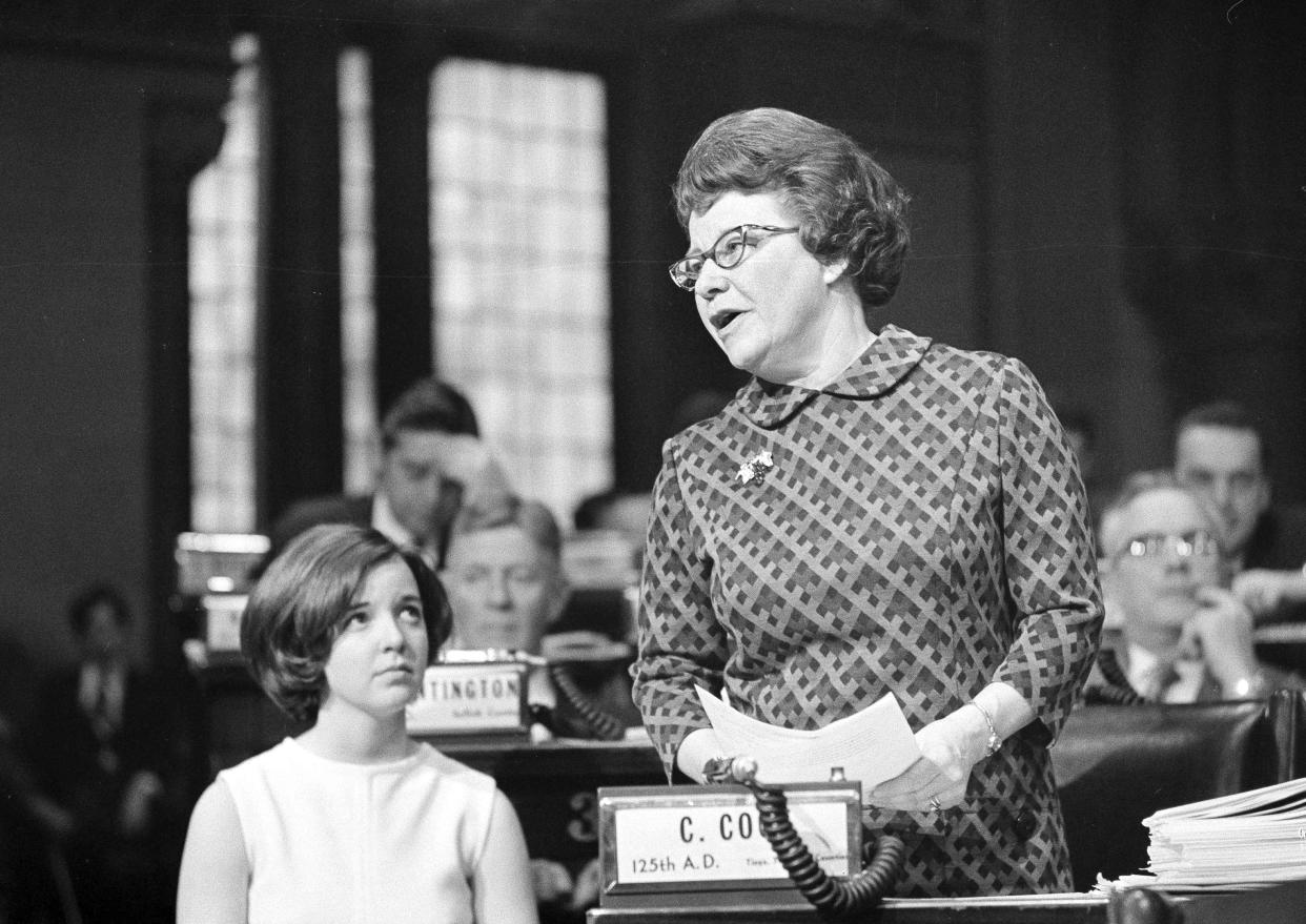 Assemblywoman Constance Cook (R-Ithaca) introduces a bill to reform New York State's abortion laws in Albany, on March 30, 1970. Watching at left is her legislative assistant, Mrs. Paul Mueller, and in the background, center, is Assemblyman Prescott Huntington (R-Smithtown) chairman of the Assembly codes committee who opposed the reform package.