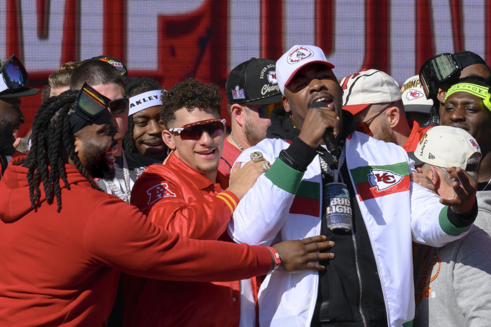 Kansas City Chiefs defensive tackle Chris Jones, right, is hugged by quarterback Patrick Mahomes, center, and defensive tackle Derrick Nnadi, at left, as he announces that he plans to play for the Chiefs next season, during their victory rally in Kansas City, Mo., Wednesday, Feb. 14, 2024. The Chiefs defeated the San Francisco 49ers Sunday in the NFL Super Bowl 58 football game. (AP Photo/Reed Hoffmann)