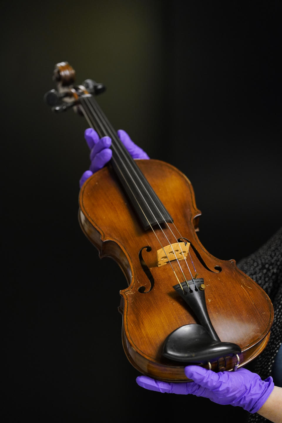 Kim Guise, curator for the National World War II Museum, shows a violin, hand made by Wilfred Lyon while a prisoner of the Germans, which will be on display at the new pavilion of the museum, in New Orleans, Friday, Sept. 29, 2023. The latest major addition to the museum is called the Liberation Pavilion. And it's ambitious in scope. The grim yet hopeful addition addresses the conflict's world-shaping legacy. (AP Photo/Gerald Herbert)