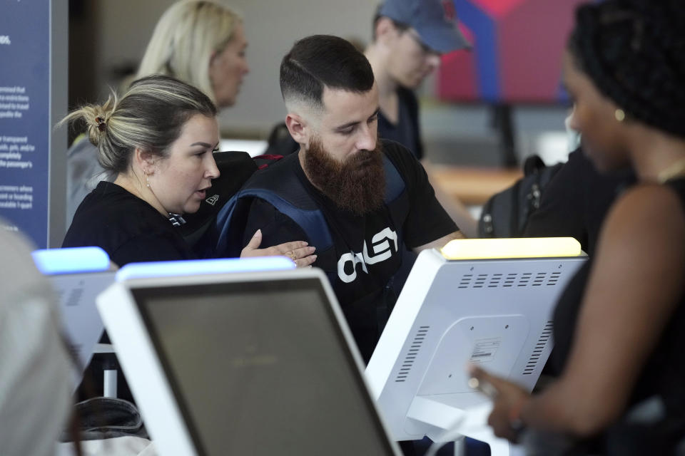 Travelers check in at an automated counter at Logan International Airport, Wednesday, June 28, 2023, in Boston. Travelers are getting hit with delays at U.S. airports again early Wednesday, an ominous sign heading into the long July 4 holiday weekend. (AP Photo/Steven Senne)