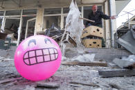 A toy shop owner gestures at his shop damaged by shelling by Azerbaijan's artillery at a market in Stepanakert, the separatist region of Nagorno-Karabakh, Saturday, Oct. 31, 2020. Nagorno-Karabakh authorities said Azerbaijani military targeted a street market in Stepanakert and residential areas of Shushi on Saturday in violation of a mutual pledge not to target residential areas made after talks in Geneva. (AP Photo)