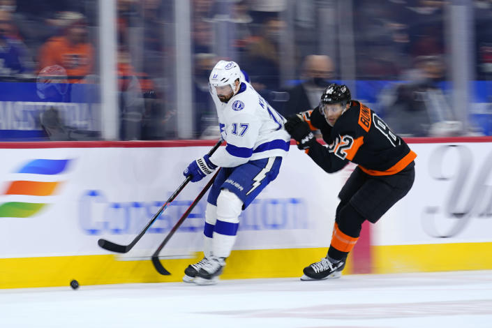 Tampa Bay Lightning's Alex Killorn, left, and Philadelphia Flyers' Connor Bunnaman chase after the puck during the second period of an NHL hockey game, Sunday, Dec. 5, 2021, in Philadelphia. (AP Photo/Matt Slocum)