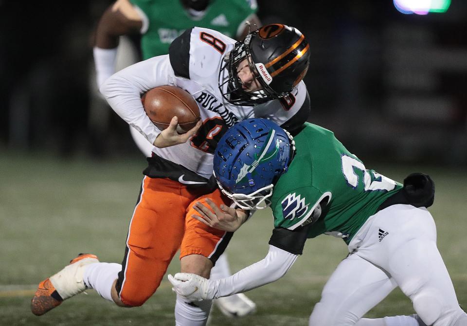 Green quarterback Trevor Van Horn puts a shoulder into Winton Woods defender Quentin Jenkins Jr. for a gain in the second half of this Division II football state semifinal at Westerville Central High School on Friday, Nov. 26, 2021.