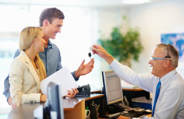 CXDWGB Senior employee handing a smiling couple the key to their car rental Car; hire; rental; couple; vehicle; company; adult;