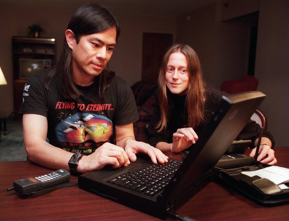 Tsutomu Shimorura, left, and Julia Menapace demonstrate how they worked together to find computer hacker Kevin Mitnick in Raleigh. They both work as freelancers in computer security. They used the equipment shown, a portable computer, a small Hewlett Packard 100LX, connected to a Mobidem from Ericsson, and a cellular phone.