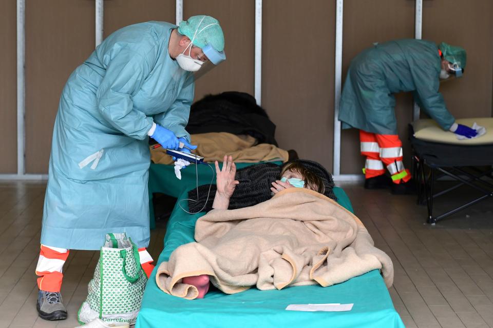 A hospital employee tends to a patient at a temporary emergency structure set up outside the Brescia hospital in Lombardy, Italy. (Miguel Medina/AFP via Getty Images)