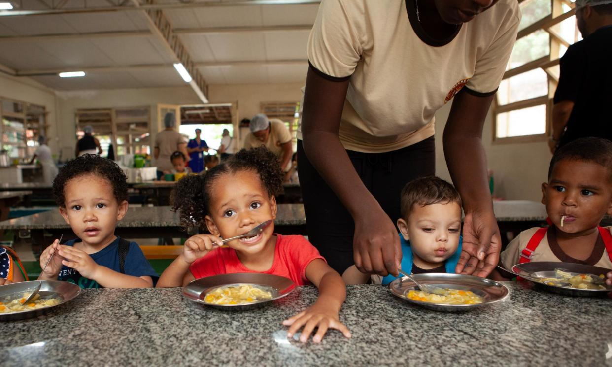 <span>Children at a free daycare centre in Rio de Janeiro eat soup made from discarded imperfect vegetables donated by Sesc Mesa Brasil, 21 February 2024. </span><span>Photograph: Ana Ionova/The Guardian</span>