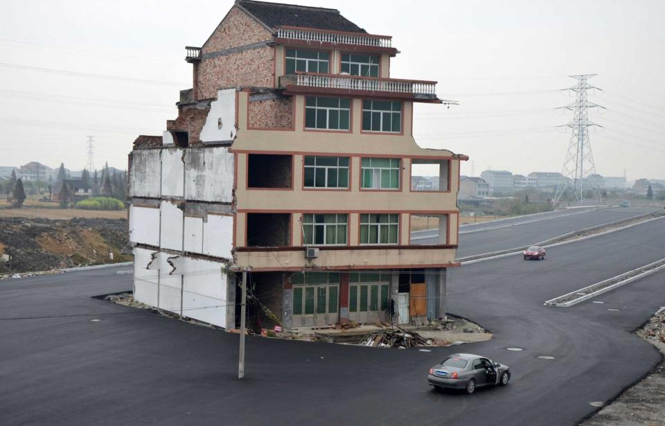 An elderly couple in Wenling, Zhejiang province, refused to move when local government officials planned to build a highway that would run through their village. The homeowner, Luo Baogen rejected the compensation on offer and was the only villager who stayed put - but this did not stop developers building a road around the house. The house has since been demolished (Rex)
