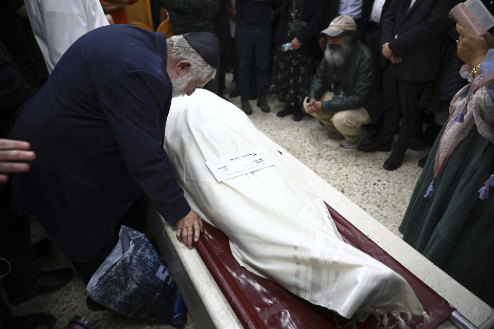 Mourners gather around the body of Eliyahu Kay, a 26-year-old immigrant to Israel from South Africa, during his funeral the day after he was killed when a Palestinian man opened fire in the Old City of Jerusalem, Monday, Nov. 22, 2021, in Jerusalem. (AP Photo/Oded Balilty)