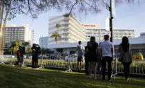 A small group of onlookers look for celebrity arrivals outside the 78th Golden Globe Awards at the Beverly Hilton, Sunday, Feb. 28, 2021, in Beverly Hills, Calif. (AP Photo/Chris Pizzello)