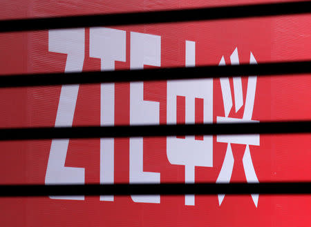FILE PHOTO - The company logo of ZTE is seen through a wooden fence on a glass door during the company's 15th anniversary celebration in Beijing April 18, 2013. REUTERS/Barry Huang/File Photo
