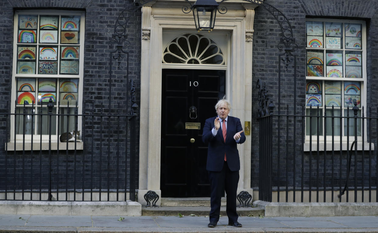 Britain's Prime Minister Boris Johnson applauds on the doorstep of 10 Downing Street, during the weekly "Clap for our Carers", in London, Thursday, May 28, 2020. The COVID-19 coronavirus pandemic has prompted a public display of appreciation for care workers. The applause takes place across Britain every Thursday at 8pm local time to show appreciation for healthcare workers, emergency services, armed services, delivery drivers, shop workers, teachers, waste collectors, manufacturers, postal workers, cleaners, vets, engineers and all those helping people with coronavirus and keeping the country functioning while most people stay at home in the lockdown. (AP Photo/Kirsty Wigglesworth)