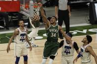 Milwaukee Bucks' Giannis Antetokounmpo dunks during the second half of an NBA basketball game against the Philadelphia 76ers Saturday, April 24, 2021, in Milwaukee. The basket was his 12,012 point as a Milwaukee Bucks player, leaving him second on the team's all-time scorers. (AP Photo/Morry Gash)