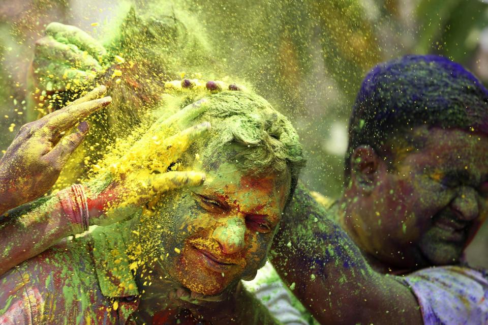 Indians smear colored powder at each other during celebrations marking Holi, the Hindu festival of colors, in Mumbai, India, Monday, March 17, 2014. The holiday, celebrated mainly in India and Nepal, marks the beginning of spring and the triumph of good over evil. (AP Photo/Rajanish Kakade)
