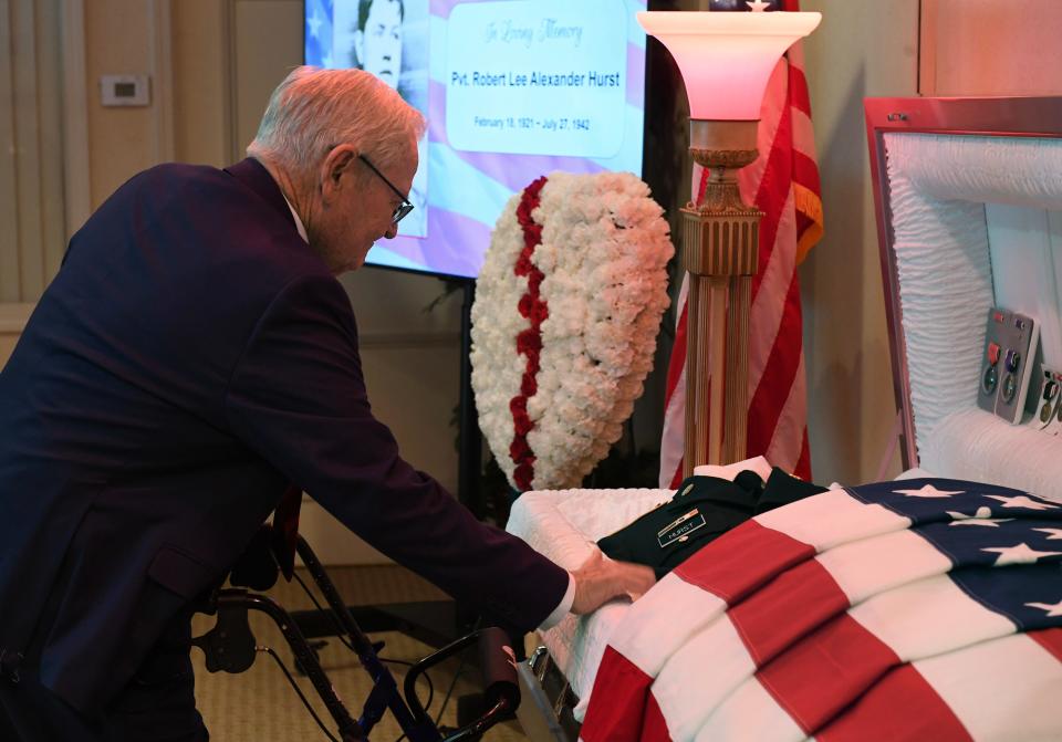 Donald Hurst, nephew of the late Pvt. Robert Lee Hurst, looks over his uncle's uniform containing his remains during a memorial service for Hurst at the Cox-Gifford Seawinds Funeral Home & Crematorium on Saturday, Feb. 17, 2024, in Vero Beach. R. L. Hurst's remains were identified fusing his extended family's DNA, bringing Hurst home from the Philippines, where he died during World War II.