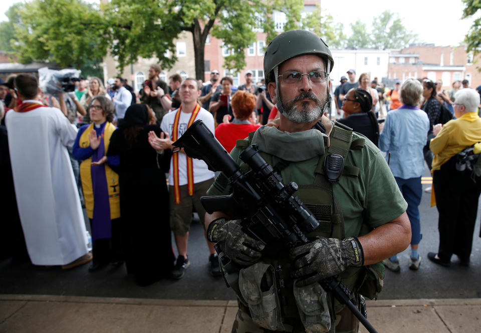 <p>A white supremacist militia member stands in front of clergy counter protesting during rally in Charlottesville, Va., Aug. 12, 2017. (Photo: Joshua Roberts/Reuters) </p>