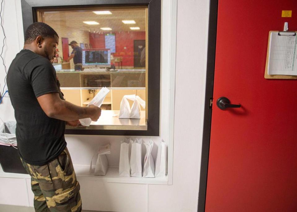 BesaMe Wellness employee Antonio Tubbs placed orders Wednesday in the store in North Kansas City. The company has both in-store pickup and delivery for items ordered online. 