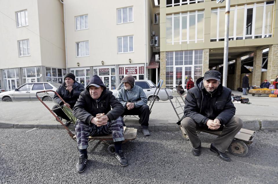 Men wait near the Abkhazian border Wednesday, Feb. 5, 2014, near Sochi, Russia. Abkhazia is a festering geopolitical sore, and the economic system still operating in these and many other parts of Russia is decidedly 19th century. As Russia opens its doors to a curious world with the Sochi Games, places like this border expose the vast contradictions still gripping the one-time superpower 21 years after the Soviet Union collapsed. (AP Photo/Morry Gash)