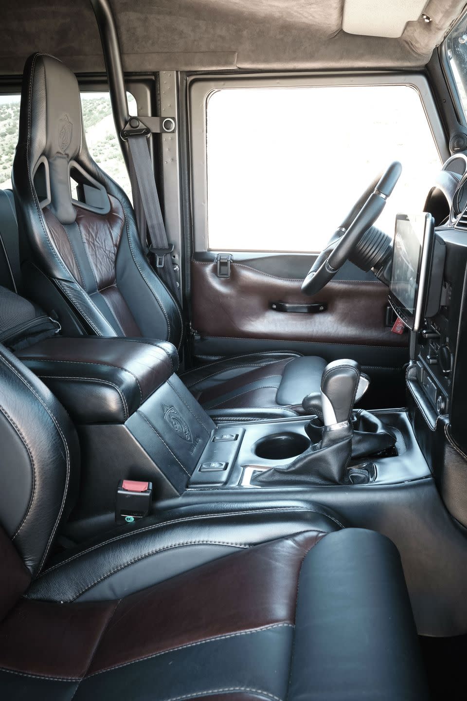 <p>The interior of a Defender, even one reimagined by a company like Himalaya, will never feel as up-to-date as a modern SUV. But this one certainly goes beyond any stock NAS Defender. </p><p>The full Ruskin leather interior, alcantara headliner, and Recaro seats make the riding inside much less utilitarian. Bonus: the seatbelt's shoulder-belt mount has been relocated to the roll cage, which allows for more comfortable seat adjustability.</p>