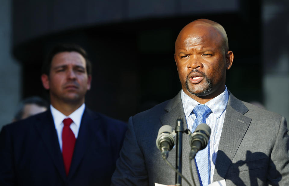 FILE - In this Jan. 11, 2019 file photo, acting Broward County sheriff Gregory Tony, right, speaks after being introduced by Florida Gov. Ron DeSantis, left, at the Broward County Sheriff's Office in Fort Lauderdale, Fla. Gov. DeSantis said on Feb. 1 that he and his staff would “in the coming days” review a state report that found the sheriff he appointed lied repeatedly about killing another teenager almost 30 years ago, his past drug use and his driving record. That was 100 days ago on Wednesday, May 11, 2022 and neither DeSantis nor his staff have made any announcement about whether he will discipline Gregory Tony. (AP Photo/Wilfredo Lee, File)