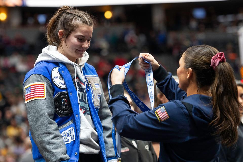 Poudre School District's Aubrey First stands at the podium for her fifth-place finish at the Colorado state wrestling tournament at Ball Arena in Denver on Saturday.