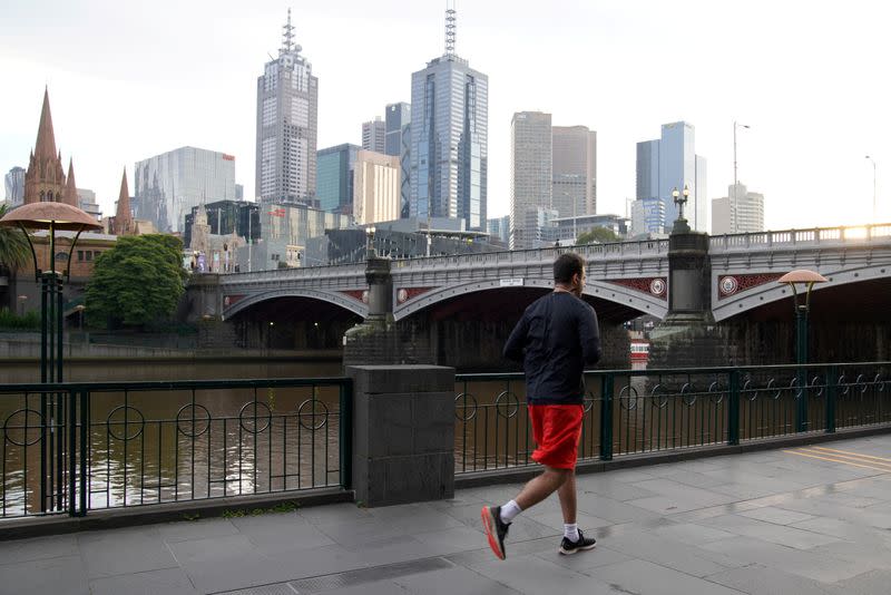 A solitary man runs along a waterway under COVID-19 lockdown restrictions in Melbourne