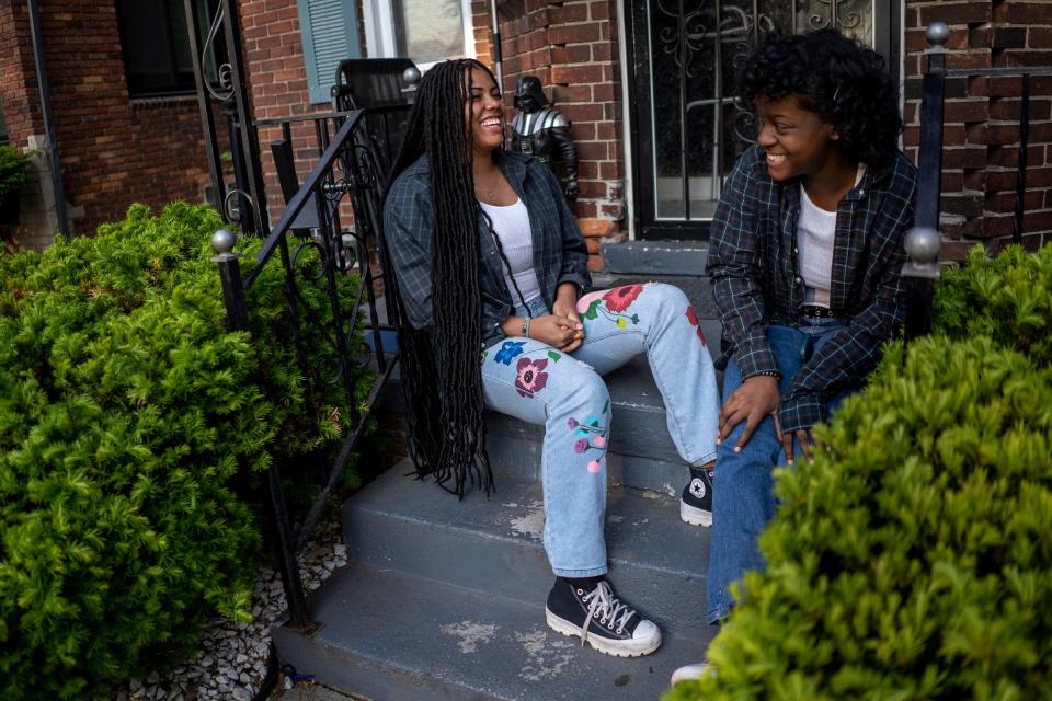 The School at Marygrove seniors Tatyana Alves, 17, left, and Julisa Shadwick, 18, talk while sitting on the front porch of Alves' home in Detroit on Wednesday, May 17, 2023. Alves, who is a part of the first high school graduating class at The School at Marygrove in Detroit, has received more than $1.7 million in scholarships. She was voted u0022Most Positiveu0022 in her historic graduating class, and she credits her positivity and selflessness, qualities she learned from her mother for her high school success.