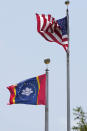 The magnolia centered banner chosen Wednesday, Sept. 2, 2020 by the Mississippi State Flag Commission flies adjacent to the American flag in a brisk wind, outside the Old State Capitol Museum in downtown Jackson, Miss. The nine member committee voted to recommend a design with the state flower. That design will go on the November ballot for voters consideration and if approved, it will become the new state flag. (AP Photo/Rogelio V. Solis)
