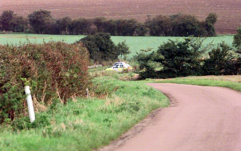 Police officers patrol the area where Hall's body was discovered in 1999 - PA