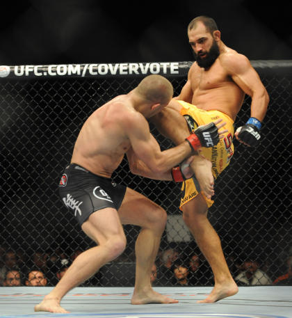 Georges St-Pierre takes a knee to the head from Johny Hendricks. (USA Today)