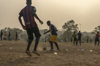 De jeunes footballeurs amateurs jouent sur un terrain en sable arborant les “lêkê”, ces fameuses sandales en plastique, à Abidjan, le 27 janvier 2024. . PHOTO JOAO SILVA/THE NEW YORK TIMES