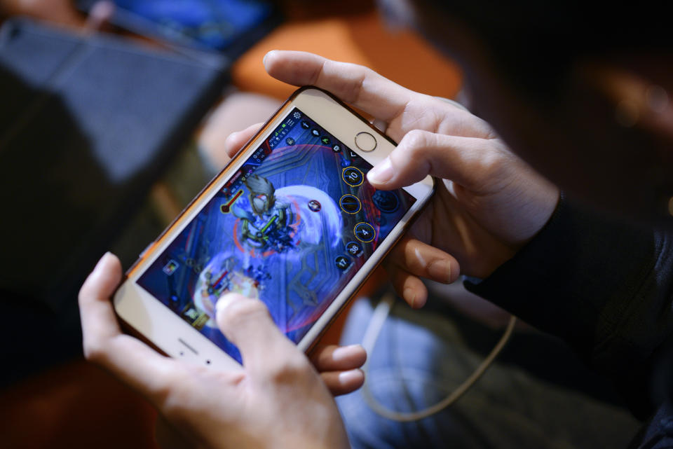 A Thai gamer playing the Garena RoV Thailand game on his mobile phone at the King of Gamers Electronic Sports competition event in Bangkok, Thailand, 16 December 2017. (Photo: Getty Images)