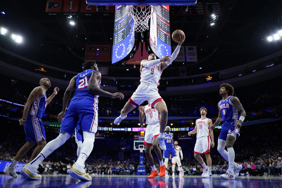 Houston Rockets' Dillon Brooks (9) goes up for a shot past Philadelphia 76ers' Joel Embiid (21) during the first half of an NBA basketball game, Monday, Jan. 15, 2024, in Philadelphia. (AP Photo/Matt Slocum)