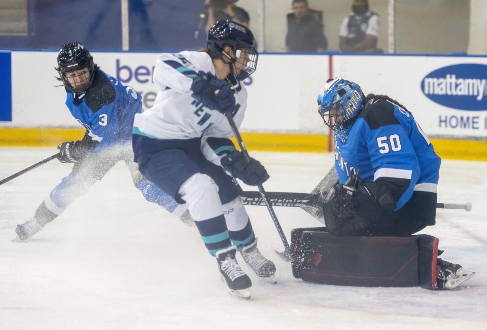 Toronto goaltender Kristen Campbell (50) makes a save on New York forward Alex Carpenter (25) as Toronto defender Jocelyn Larocque (3) looks on during first period PWHL action in Toronto on Monday, Jan. 1, 2024. (Frank Gunn/The Canadian Press via AP)