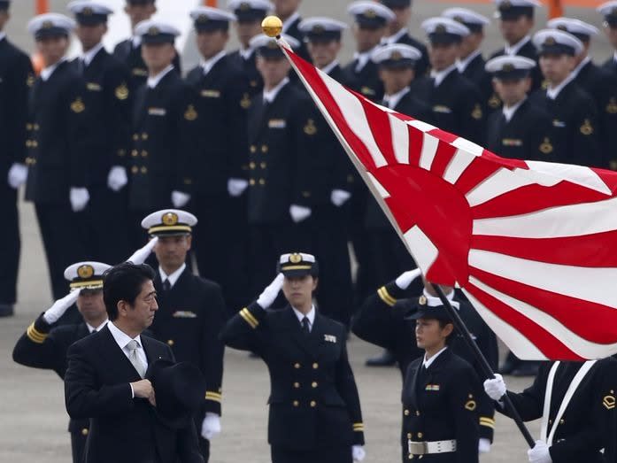 Japan's Prime Minister Shinzo Abe (L) reviews members of Japan Self-Defense Force (JSDF) during the JSDF Air Review, to celebrate 60 years since the service's founding, at Hyakuri air base in Omitama, northeast of Tokyo, in this October 26, 2014 file photo. REUTERS/Toru Hanai/Files