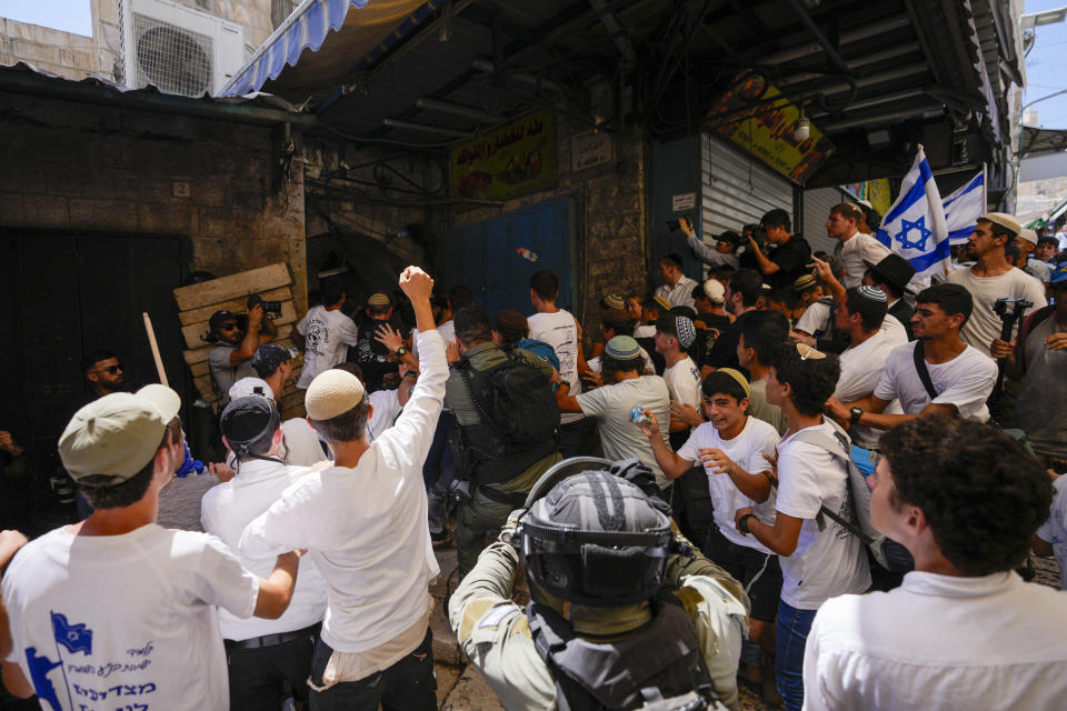 Policías de Israel separan a israelíes de palestinos en una calle del barrio musulmán en la Ciudad Vieja de Jerusalén, poco antes de una marcha de nacionalistas judíos en la zona en el Día de Jerusalén, una fiesta israelí que celebra la captura del Jerusalén oriental en la Guerra de los Seis Días, el miércoles 5 de junio de 2024. (AP Foto/Ohad Zwigenberg)