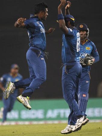 Sri Lanka's Angelo Mathews congratulates bowler Seekkuge Prasanna (L) after he successfully dismissed West Indies' Lendl Simmons during their semi final-match in the ICC Twenty20 World Cup at the Sher-E-Bangla National Cricket Stadium in Dhaka April 3, 2014. REUTERS/Andrew Biraj