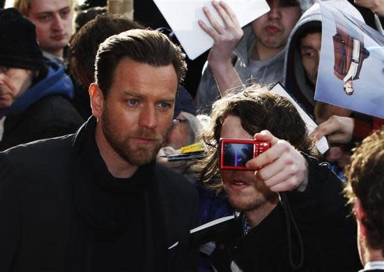 Actor Ewan McGregor has a photograph taken with a fan as he arrives for the European premiere of "Salmon Fishing in the Yemen" in London, April 10, 2012.