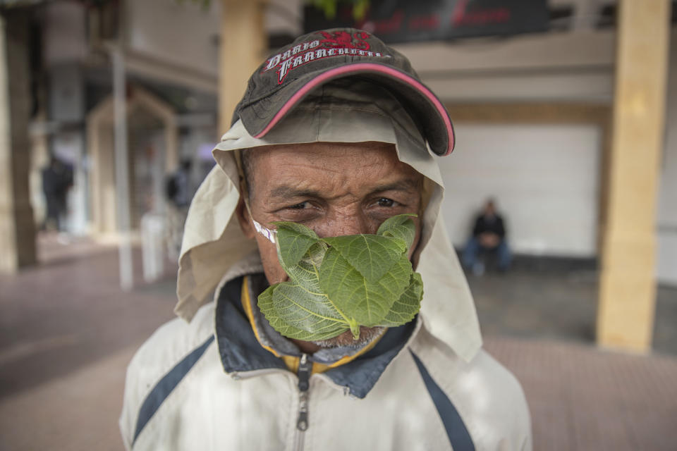 A street vendor, Abderrahim, 55, poses for a portrait while wearing a makeshift face mask made of fig leaves, in the Medina of Rabat, Morocco, March 18, 2020. (AP Photo/Mosa'ab Elshamy)
