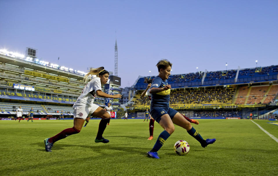 Boca Juniors' Yamila Rodriguez, right, shields the ball from Lanus' Mayra Gauna during the Superliga women's soccer tournament in Buenos Aires, Argentina, Saturday, March 9, 2019. The women competed in one of Argentina's most famous stadiums on Saturday, a milestone for the female players who are fighting for the same rights as male soccer players in the country's most popular sport. (AP Photo/Natacha Pisarenko)