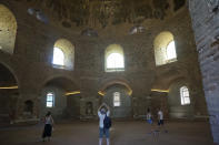 Visitantes admiran los mosaicos bizantinos de la gigantesta cúpula de la Rotonda en Salónica (Grecia) el 25 de junio del 2022. (AP Photo/Giovanna Dell'Orto)