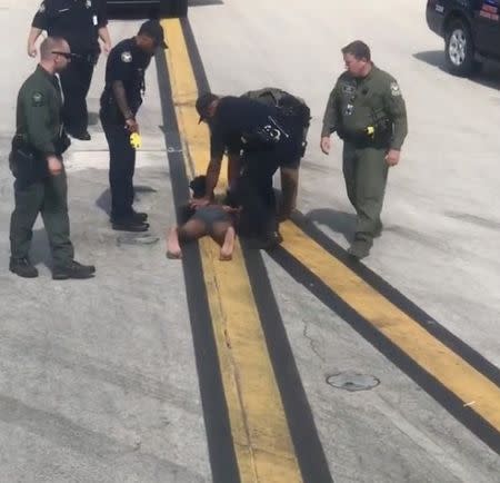 Police arrest a man in underpants on the tarmac at the airport in Atlanta, Georgia, U.S., June 26, 2018 in this picture obtained from social media. TK JAMES/via REUTERS